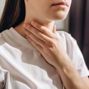 Person Holding Their Neck And Feeling Their Thyroid