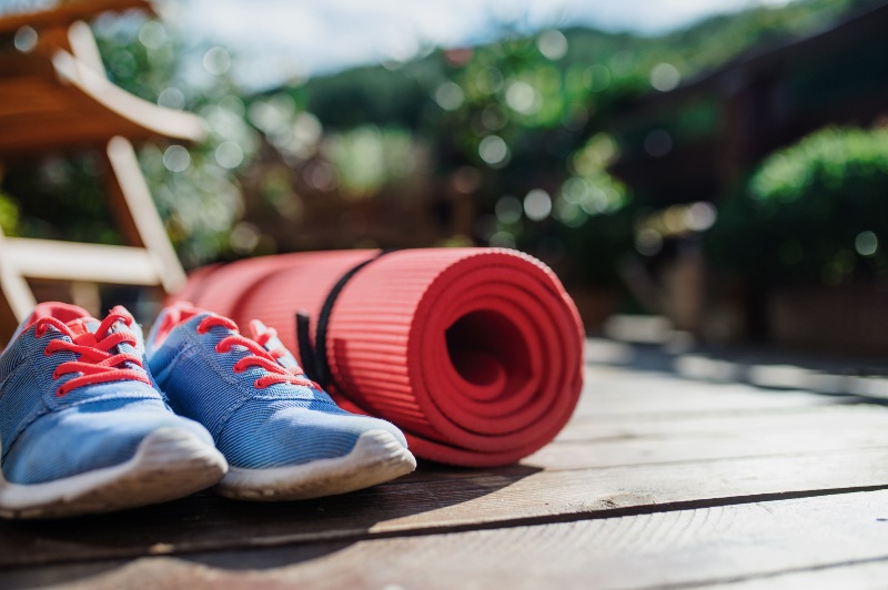 Blue running shoes next to yoga mat