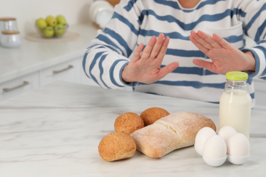 Woman signals stop with bread and eggs, highlighting histamine intolerance in San Diego, CA