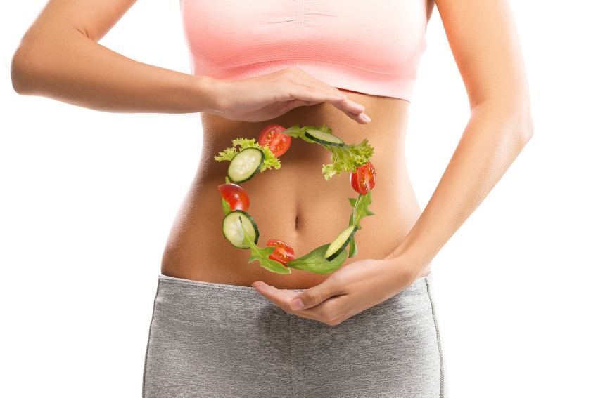 A woman displays a circle of vegetables emphasizing digestive health improvement in San Diego, CA