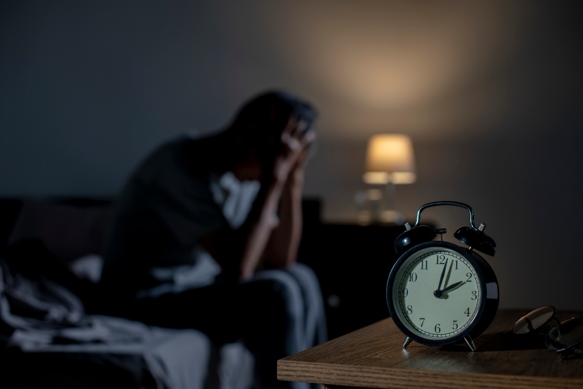 A man on a bed illustrating functional medicine for sleep disorders in San Diego, CA
