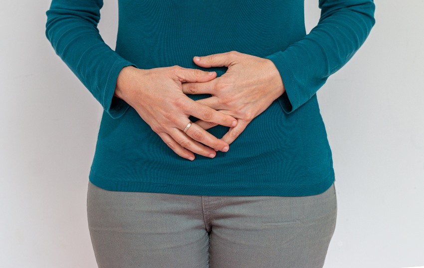 A woman with her hands on stomach reflecting the impact of Celiac Disease on life in San Diego, CA