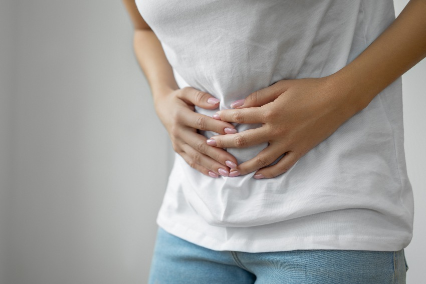 A man clutches his stomach illustrating the challenges of gastroesophageal reflux in San Diego, CA